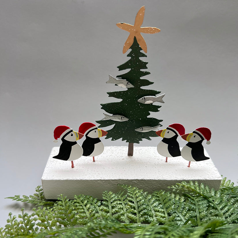 4  jolly puffins decorating a christmas tree